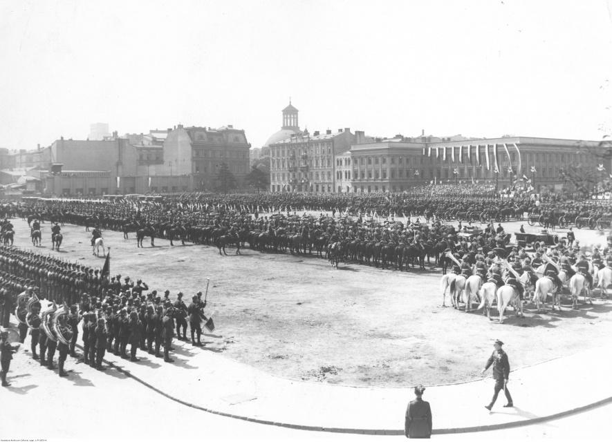 Oddziały wojskowe zgromadzone na placu Piłsudskiego przed defiladą w święto 3 Maja 1934. Widoczny Pałac Saski, budynek przy Królewskiej 6 (przylegający do Pałacu Saskiego), po lewej Instytut Propagandy Sztuki (Królewska 13), pałac Leopolda Kronenberga (plac Małachowskiego 4), w oddali kopuła kościoła ewangelicko-augsburskiego pw. Świętej Trójcy, fot. Jan Binek, Narodowe Archiwum Cyfrowe: 1-P-2872-4

